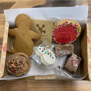 Box with a selection of christmas treats, cupcake, gingerbreadman, brownies, christmas cookies